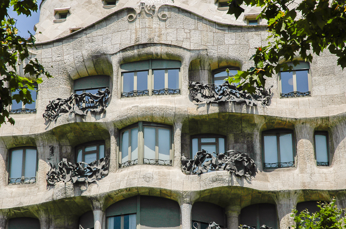 A close up look at a section of the Pedrera`s facade, iron balconies and windows.